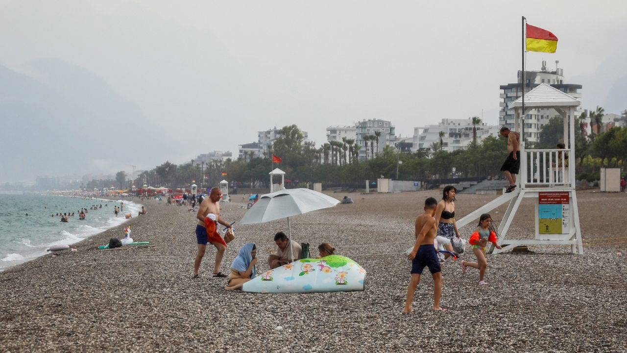 Antalya’da sağanak yağış: Bazı tatilciler denizde yüzmeye devam etti